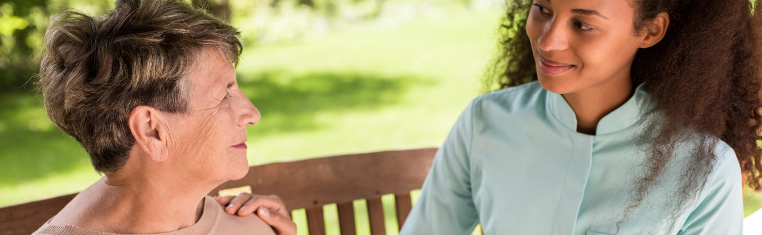 Panorma of volunteer in rest home and senior woman